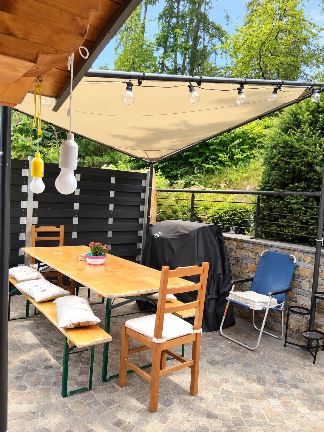 Il tavolo e le sedute sotto la vela in giardino