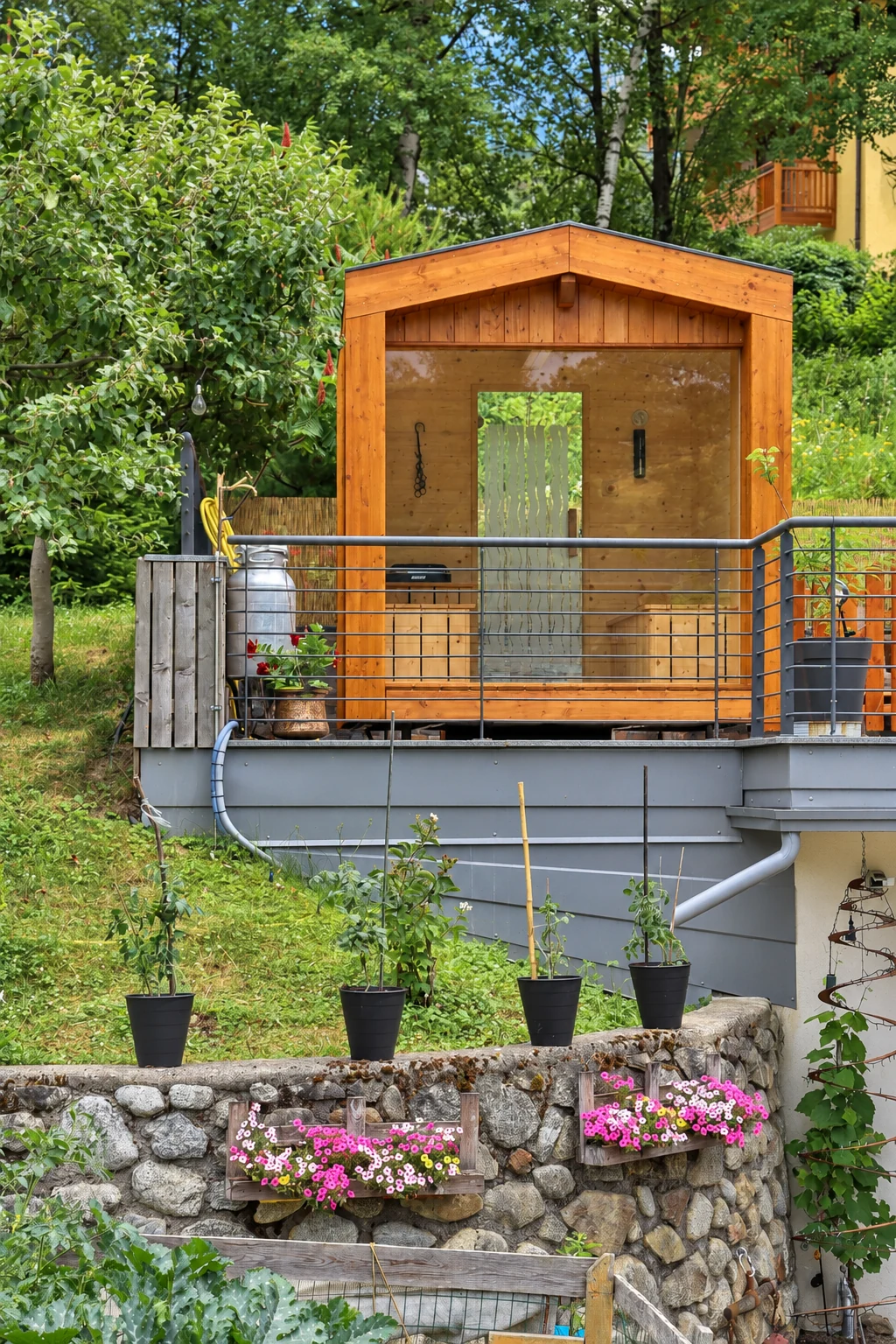 La sauna in legno con vetrata, tra gli alberi del giardino